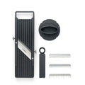 Product image of Global 9.5cm mandolin showing the mandolin vegetable slicer the finger safety guard and the 3 additional toothed blades with a plastic case for different styles of cutting vegetables.
