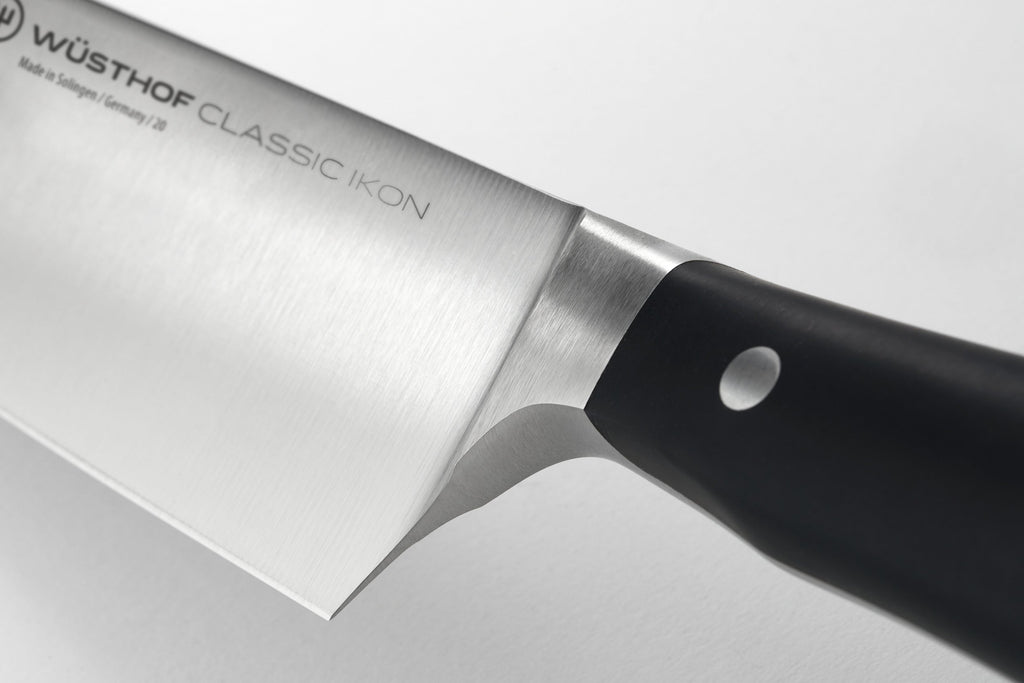 Classic Ikon Asian Utility Knife 12 cm | 4 1/2 inch featuring a finely polished stainless steel blade and ergonomic black handle with a smooth bolstered grip.